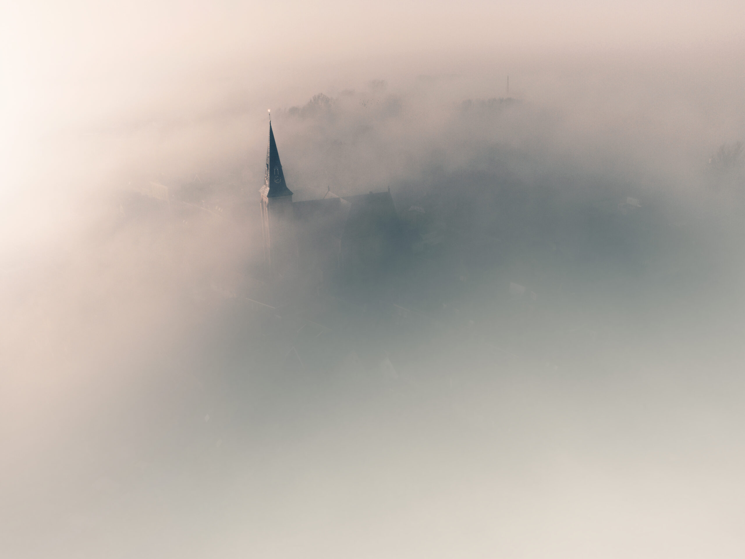 Luchtfoto van de kerk van Genemuiden in de mist, gemaakt door DutchDroneBird